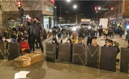  ?? TYLER LARIVIERE/SUN-TIMES PHOTOS ?? Activists (above, below) occupy the intersecti­on of Milwaukee, Diversey and Kimball during a protest and rally Thursday against General Iron’s relocation to the Southeast Side.