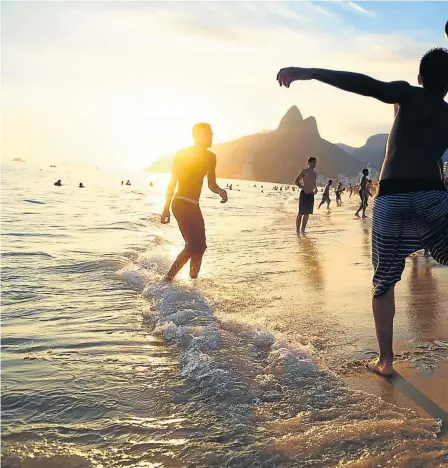  ?? Pictures: GALLO/ALAMY ?? PITCH PERFECT: Young men play football on Ipanema beach, right, and a man rock climbs near Sugarloaf Mountain as tourists look on in Rio de Janeiro, below