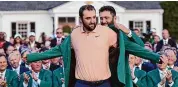  ?? David J. Phillip/Associated Press ?? Jon Rahm, of Spain, puts the green jacket on winner Scottie Scheffler after the Masters golf tournament at Augusta National Golf Club Sunday in Augusta, Ga.