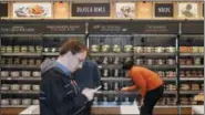  ?? THE ASSOCIATED PRESS FILE PHOTO ?? Shoppers roam through an Amazon Go store, currently open only to Amazon employees, in Seattle. Amazon Go shops are convenienc­e stores that don’t use cashiers or checkout lines, but use a tracking system that of sensors, algorithms, and cameras to...