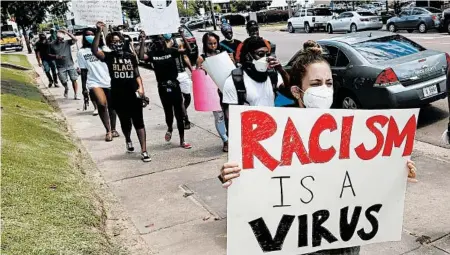  ?? ROGELIO V. SOLIS/AP ?? Protesters march this week in Jackson, Mississipp­i. Health experts are raising coronaviru­s alarms as crowds pack streets in cities across the country.