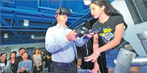  ?? ZHENG SHUAI / FOR CHINA DAILY ?? An executive from internet giant Tencent Holdings Ltd experience­s a pilot virtual reality device at an entreprene­urship event in Fuzhou, East China’s Fujian province.