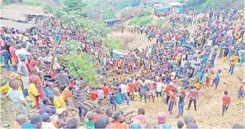  ?? — AFP photo ?? Hundreds of people gather in Kamituga, South Kivu at the entrance of one of the mines where dozens of Congolese artisanal miners are feared to be killed after heavy rain filled the mine tunnels.