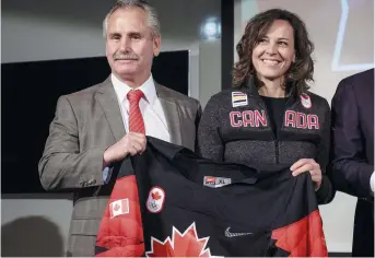  ??  ?? L’entraîneur-chef d’Équipe Canada aux Jeux olympiques de Pyeongchan­g, Willie Desjardins, et la chef de mission Isabelle Charest montrent le chandail que porteront les hockeyeurs canadiens. - La Presse canadienne: Jeff McIntosh