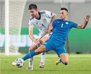  ??  ?? Declan Gallagher closes in on Israel danger man Eran Zahavi.