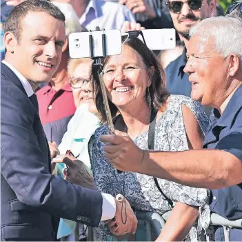  ?? FOTO: DPA ?? Ein Selfie fürs Volk: Emmanuel Macron (l.) gestern nach der Stimmabgab­e im nordfranzö­sischen Le Touquet.