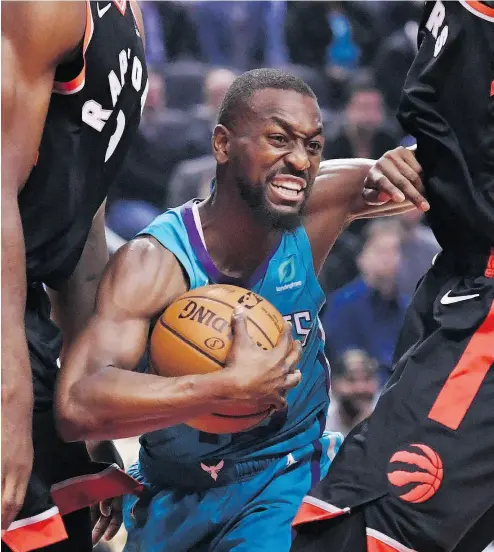 ?? NATHAN DENETTE / THE CANADIAN PRESS ?? Charlotte guard Kemba Walker tries to get between Raptors forwards Serge Ibaka and Pascal Siakam.