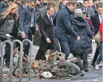  ?? ETIENNE LAURENT / EFE ?? Revista. Macron (c) pasa junto a una motociclet­a calcinada, ayer en París.