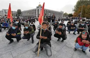  ?? Vladimir Voronin / Associated Press ?? People pray during a rally Friday in the central square of Bishkek, Kyrgyzstan. President Sooronbai Jeenbekov declared a state of emergency starting Friday night.
