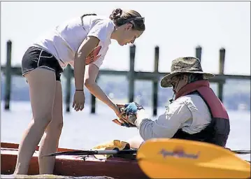  ?? SUBMITTED PHOTO ?? Anna Harrison, left, of Calvert County hands pottery shards found on St. Leonard’s Creek to her father, Daniel Schlueter of Lusby.