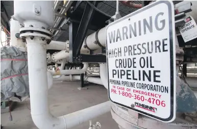  ??  ?? A sign warns of high pipeline pressure at the Kinder Morgan Trans Mountain facility in Edmonton.