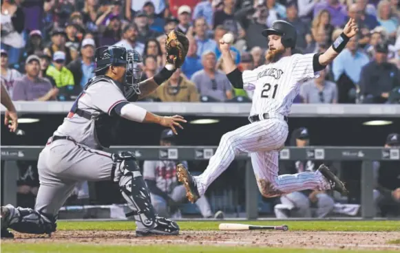  ?? John Leyba, The Denver Post ?? Rockies catcher Jonathan Lucroy beats the throw to Atlanta Braves catcher Kurt Suzuki to score on Trevor Story’s single during the third inning Wednesday night at Coors Field. Lucroy’s run gave Colorado a 6-0 lead. Story later hit two home runs,...