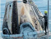  ?? Picture: REUTERS / BILL INGALLS ?? TOUCHDOWN: A member of the support team on the SpaceX Crew Dragon Endeavour spacecraft checks the craft in the Gulf of Mexico.