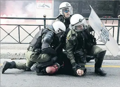  ?? YORGOS KARAHALIS / AP ?? Agents antiavalot­s detenint un home en els aldarulls que hi va haver al final de la manifestac­ió