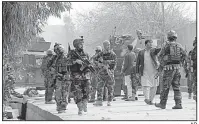  ?? AP ?? Afghan security forces patrol Wednesday at the scene of a suicide attack on the office of Save the Children in Jalalabad.