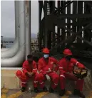  ?? AP ?? Workers at an oil refinery in Venezuela take a break