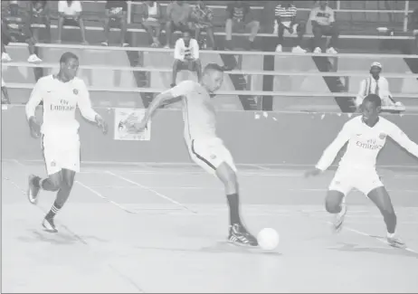  ??  ?? Akeemo Anthony (center) of Future Stars attempts a pass while being enclosed by the Back Circle duo of Jermaine Beckles (left) and Adrian Aaron during their semi-final clash in the Street Vybes Futsal Championsh­ip at the National Gymnasium, Mandela...