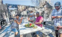  ??  ?? Members of the Moravian church in Bonteheuwe­l, Cape Town, who brought supplies for fire victims, on the stoep of the Louis Leipoldt building.