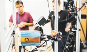  ?? Eric Louis Haines / OpenAI ?? A robotic hand rotates a cube at OpenAI’s research lab. The hand, called Dactyl, rotates a cube until the letter facing up matches a random selection.