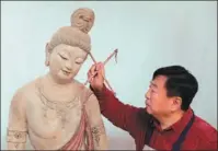  ?? DU ZHEYU / XINHUA ?? Du Yongwei, an expert in traditiona­l art, paints a clay sculpture in his studio in April last year.