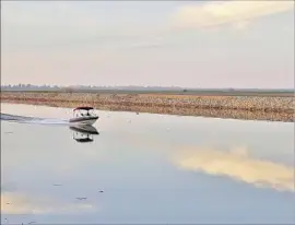  ?? Katie Falkenberg Los Angeles Times ?? A BOAT navigates Whiskey Slough in the Sacramento-San Joaquin Delta, the hub of California’s waterworks. Delta growers strongly oppose the tunnel project.