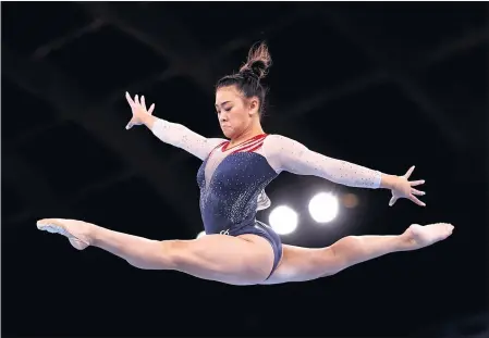  ?? JULIAN FINNEY — GETTY IMAGES ?? Sunisa Lee competes on the balance beam during the all-around final on Thursday. She is the first U.S. Olympic champion of Hmong descent.