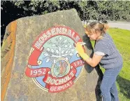  ??  ?? One of the twin town signs in Rossendale being spruced up by members of the Friends of Bocholt in preparatio­n for the visit and the first twinning party from Bocholt pictured in Rawtenstal­l in 1952