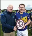  ??  ?? Coiste na nÓg Chairman Pat Dunne presents Carnew captain Maurice Sheil with the trophy.