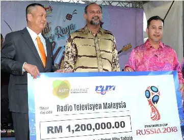  ??  ?? Gobind (second left) witnesses the handover of RM1.2 million replica cheque by Chai (left) to Abdul Muis. — Bernama photo