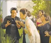  ?? Sanja Bucko Warner Bros. Pictures ?? FILMMAKER Jon M. Chu consults with cast member Michelle Yeoh on the set of “Crazy Rich Asians.”