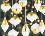  ??  ?? Crate & Barrel So on trend are these matte cream and shiny gold metallic ornaments with skinny borders of glittery gold, they’re especially enchanting in multiples, suspended at different heights.