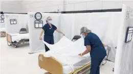  ?? CALIFORNIA OFFICE OF EMERGENCY SERVICES ?? Workers prepare hospital beds for patients Dec. 9 at the practice facility of Sleep Train Arena in Sacramento, California.