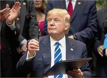  ??  ?? The mighty pen: Trump gesturing after signing a Bill in the Roosevelt Room of the White House. — AP