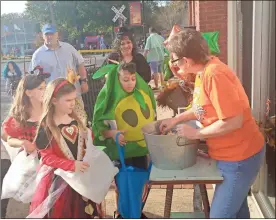  ?? / Sean Williams ?? Local merchants provided candy and smiles to a trio of children during the Downtown Rockmart Festival of Treats on Halloween.