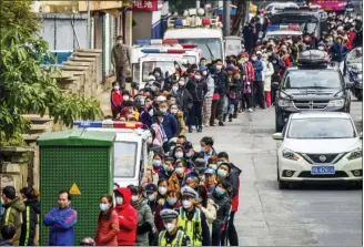  ?? CHINATOPIX VIA THE ASSOCIATED PRESS ?? People line up to buy face masks from a medical supply company in Nanning in southern China’s Guangxi Zhuang Autonomous Region.