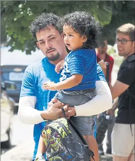  ?? PAUL SANCYA — THE ASSOCIATED PRESS ?? Ever Reyes Mejia of Honduras carries his son after being reunited and released by U.S. Immigratio­n and Customs Enforcemen­t in Grand Rapids, Mich.