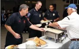  ?? The Sentinel-Record/Richard Rassmussen ?? GIVING BACK: St. Mary’s of the Springs Catholic Church member Don Borchert, right, serves breakfast to Hot Springs Fire Department Driver Shannon McDaniel, left, HSPD Officer Shawn Woodall and Officer Richard Nunez during a first responder breakfast...
