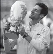  ?? JOHN MINCHOLLO/AP PHOTO ?? Novak Djokovic holds the Rookwood Cup after defeating Roger Federer in Sunday’s men’s singles final at the Western &amp; Southern Open tournament in Mason, Ohio.