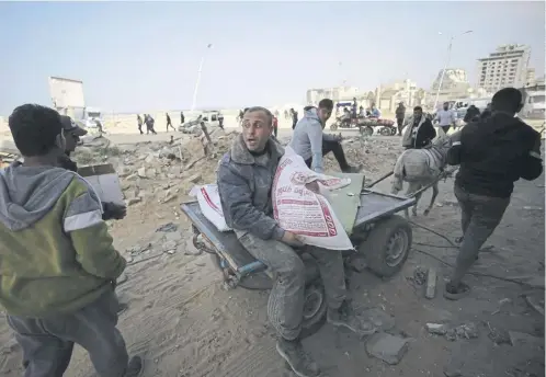  ?? ?? Palestinia­ns receive a trickle of humanitari­an aid in Gaza City yesterday. Lord Cameron, below, is leading calls for Israel to allow more aid