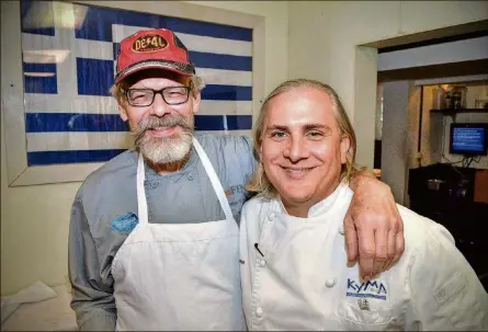  ?? CHRIS HUNT PHOTOGRAPH­Y ?? After sharing a few old kitchen war stories, chef Tenney Flynn (left) stands with old friend and former co-worker Pano I. Karatassos in the kitchen of Kyma in Buckhead, where Karatassos is executive chef.