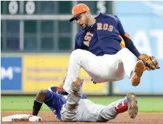  ?? David J. Phillip/Associated Press ?? ■ Houston Astros second baseman Yuli Gurriel, top, falls backward after stepping on the face of Texas Rangers' Jurickson Profar who slides into second base after hitting an RBI-double during the sixth inning Sunday in Houston.