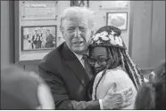  ?? JASON ALLEN/AP PHOTO ?? Republican presidenti­al candidate and former President Donald Trump hugs Michaelah Montgomery, a local conservati­ve activist, as he visits a Chick-fil-A earlier this month in Atlanta.