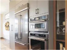  ??  ?? Black stainless steel appliances shine next to the contempora­ry cabinets.