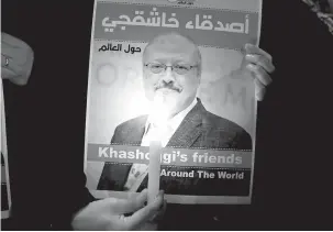  ?? — Gambar Reuters ?? TURUT BERSIMPATI: Seorang penunjuk perasaan membawa poster dengan gambar Khashoggi di luar konsulat Arab Saudi di Istanbul, Turki pada 25 Oktober lepas.
