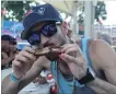  ?? ALLAN BENNER THE ST. CATHARINES STANDARD ?? Justin Priolo devours barbecued ribs by Miss Piggy’s World Famous BBQ, during the Rotary Ribfest.
