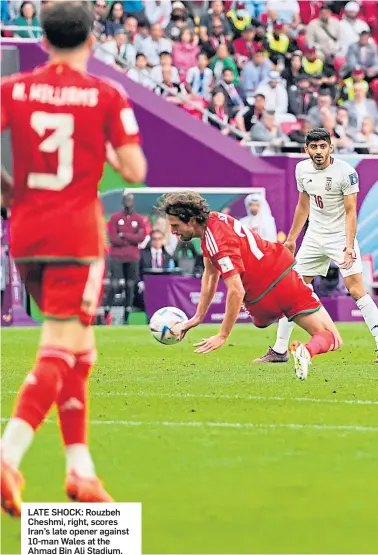  ?? ?? LATE SHOCK: Rouzbeh Cheshmi, right, scores Iran’s late opener against 10-man Wales at the Ahmad Bin Ali Stadium.