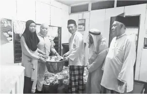  ??  ?? DEMI KESEJAHTER­AAN: Awang Husaini (tiga kanan) menyampaik­an raga makanan sumbangan Yayasan Afat Rahman kepada salah seorang penerima.