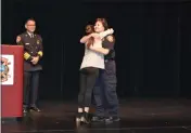  ?? NICK SESTANOVIC­H — THE REPORTER ?? Vacaville Fire Chief Kris Concepcion, left, looks on as office assistant Mary Sanner, center, hugs her mother, Terri, following Terri's promotion to fire prevention specialist.