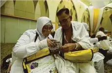  ??  ?? FATIMAH bersama suami, Dahlan antara 150 jemaah haji kumpulan pertama dari Sabah yang berlepas ke Tanah Suci Makkah.