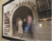  ??  ?? Gabe Whelan, Miramar co-owner, is reflected in one of the many historic pictures at the restaurant.